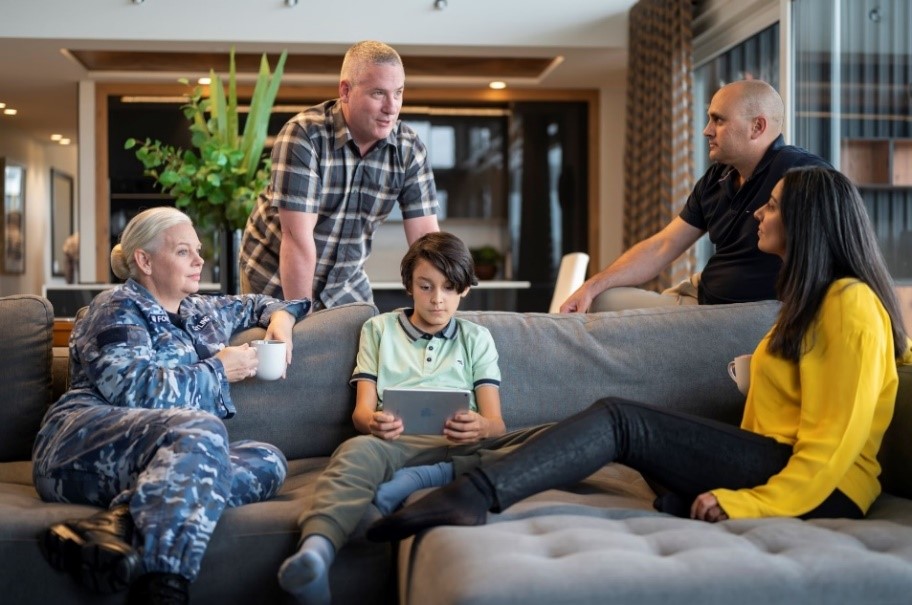 Family relaxing on sofa, including a woman in Air Force uniform