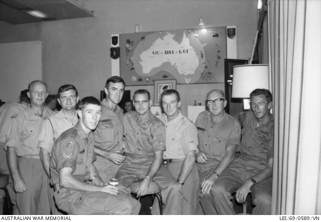 Black and white photo of eight men in uniform posing for camera