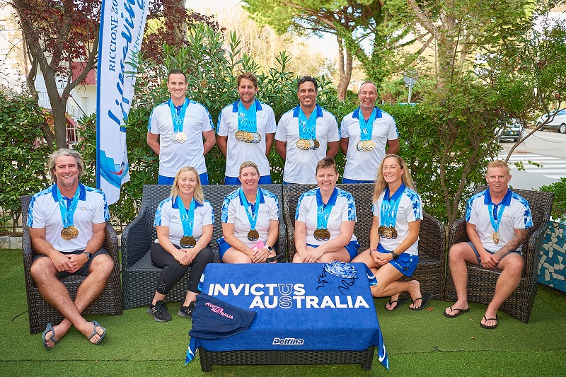 Ten men and women wearing medals pose for photo