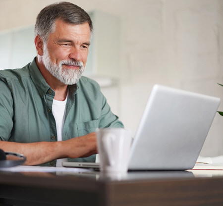 man at desk working on laptop