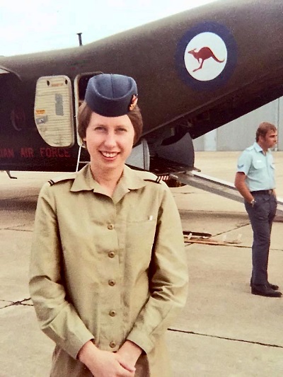Megan Pearson stands in uniform in front of an RAAF plane.