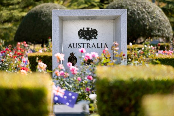 Military memorial stone plinth with flowers