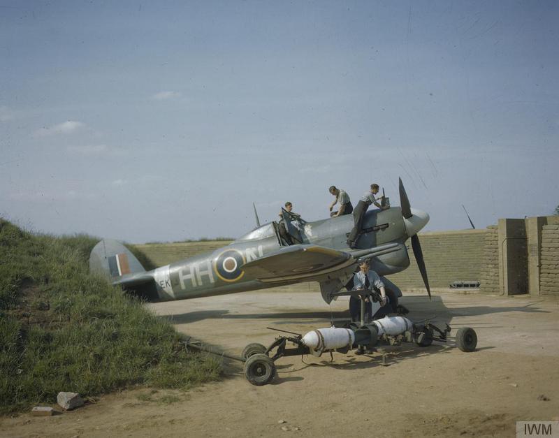 Large fighter bomber parked with five men in uniform working on it