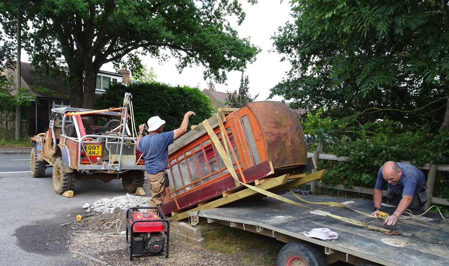 Ancient phone box being loaded onto flatbed truck