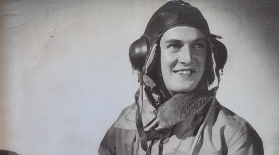 Black and white photo of smiling young man in flight gear