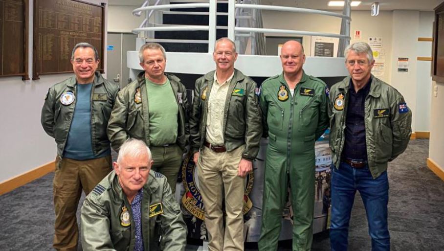 Six older men partially dressed in RAAF uniforms pose for the camera