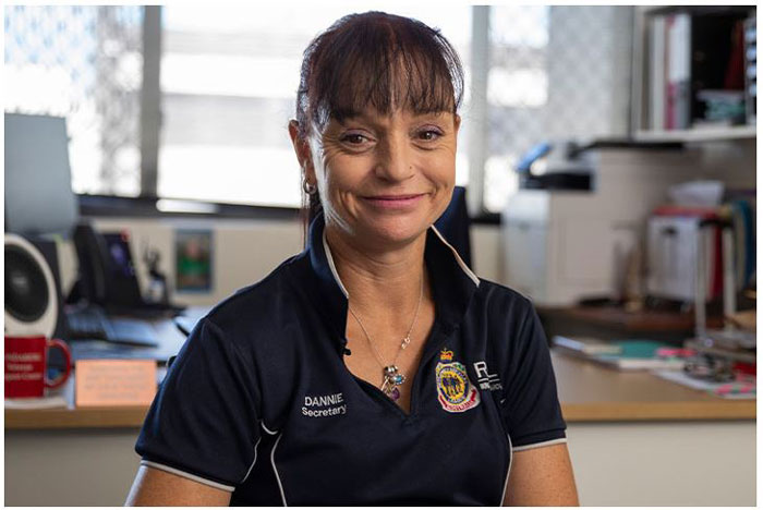 <br />
A photograph of a woman with a dark blue polo and her hair tied back smiling
