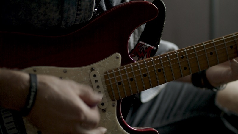 Close up photo of hands playing a guitar
