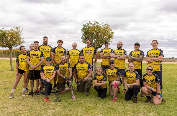 A group of people in Team Veteran T-shirts pose for camera