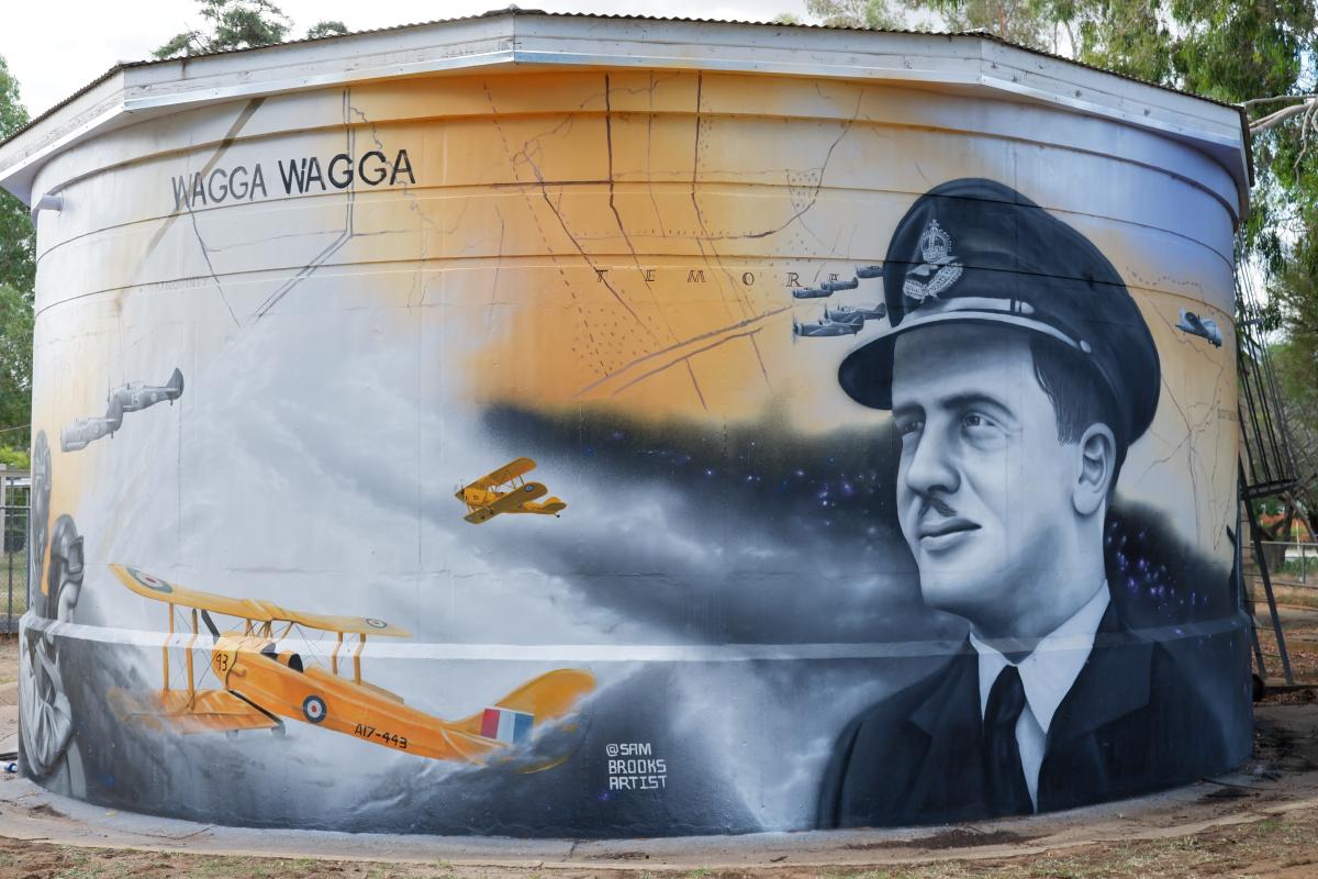 Mural showing airman and biplanes painted on large water container