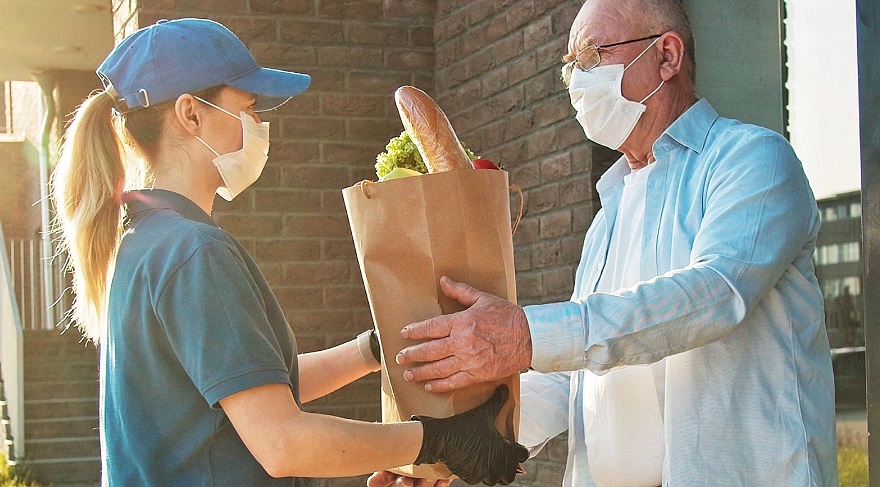 Courier wearing face mask delivers to man wearing face mask