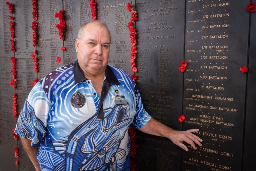 Australian War Memorial Indigenous Liaison Officer Michael Bell places a poppy beside the name of Private Ngakyunkwokka on the Roll of Honour.