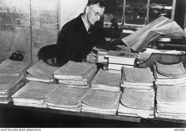 Man at desk covered in files