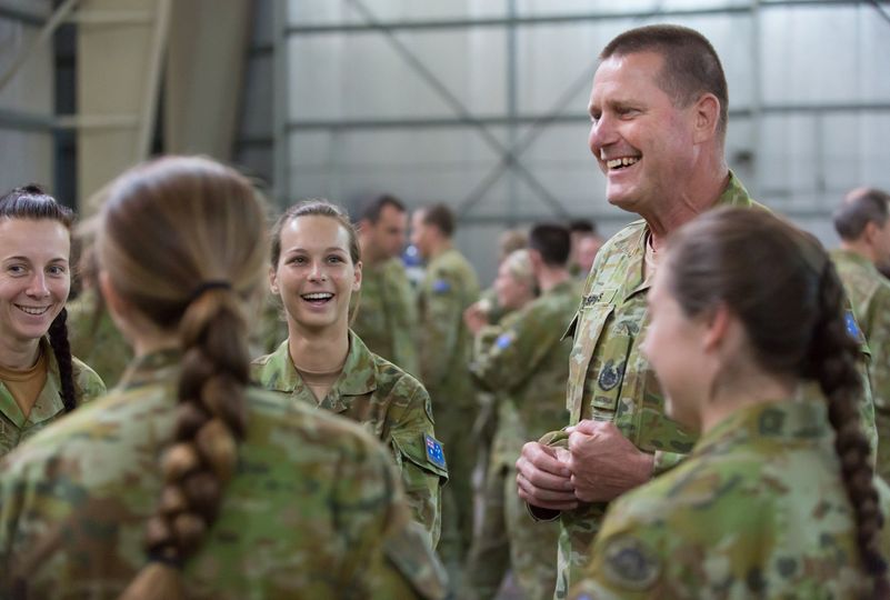 Smiling man in uniform addressing young soldiers