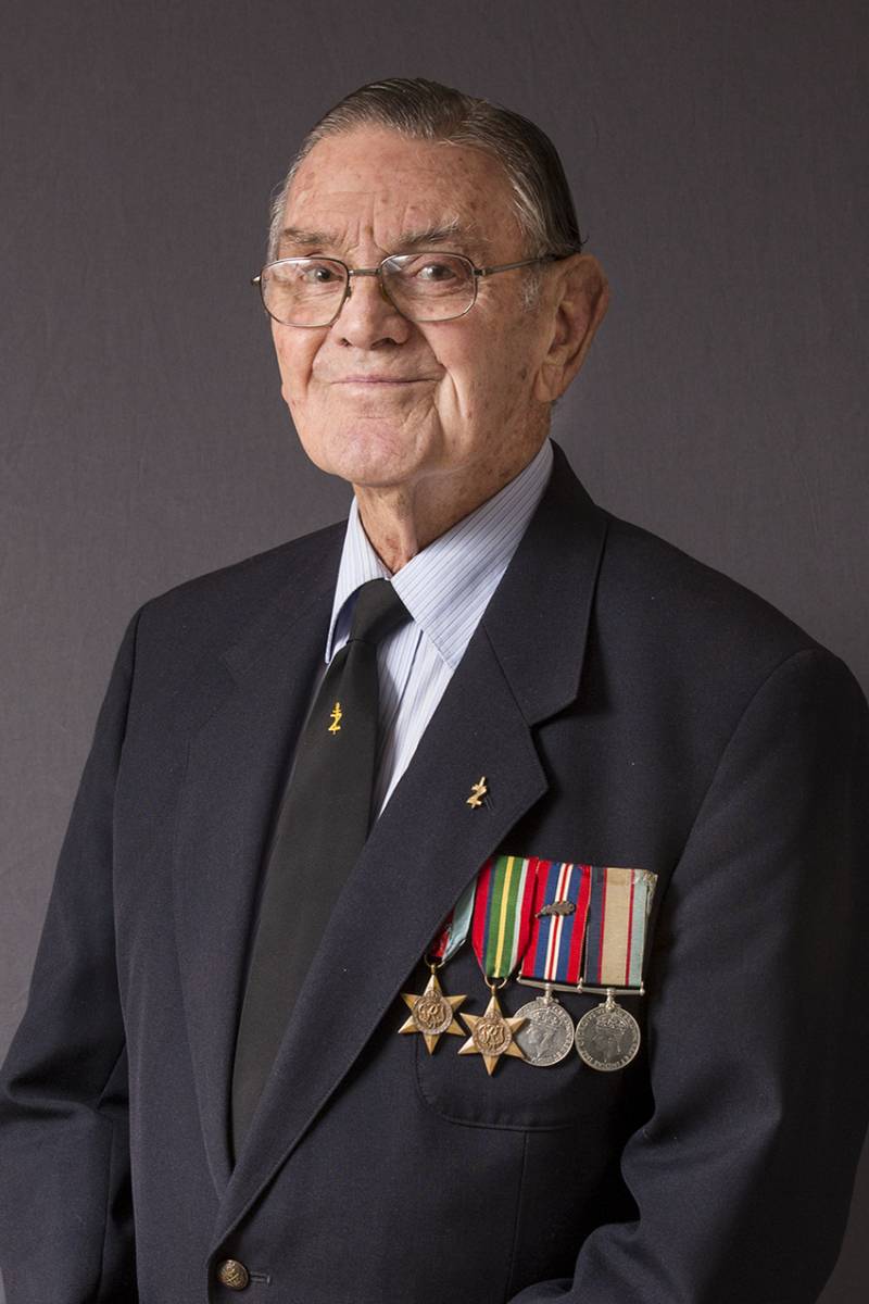 Studio photo portrait of elderly man wearing medals and on his lapel what is probably a badge indicating Z Force.