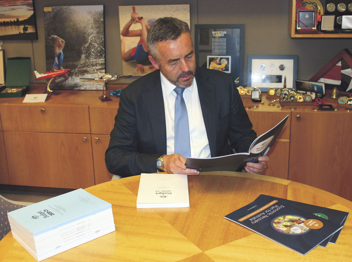 Minister Chester reviewing the Budget 2020–21 documents.