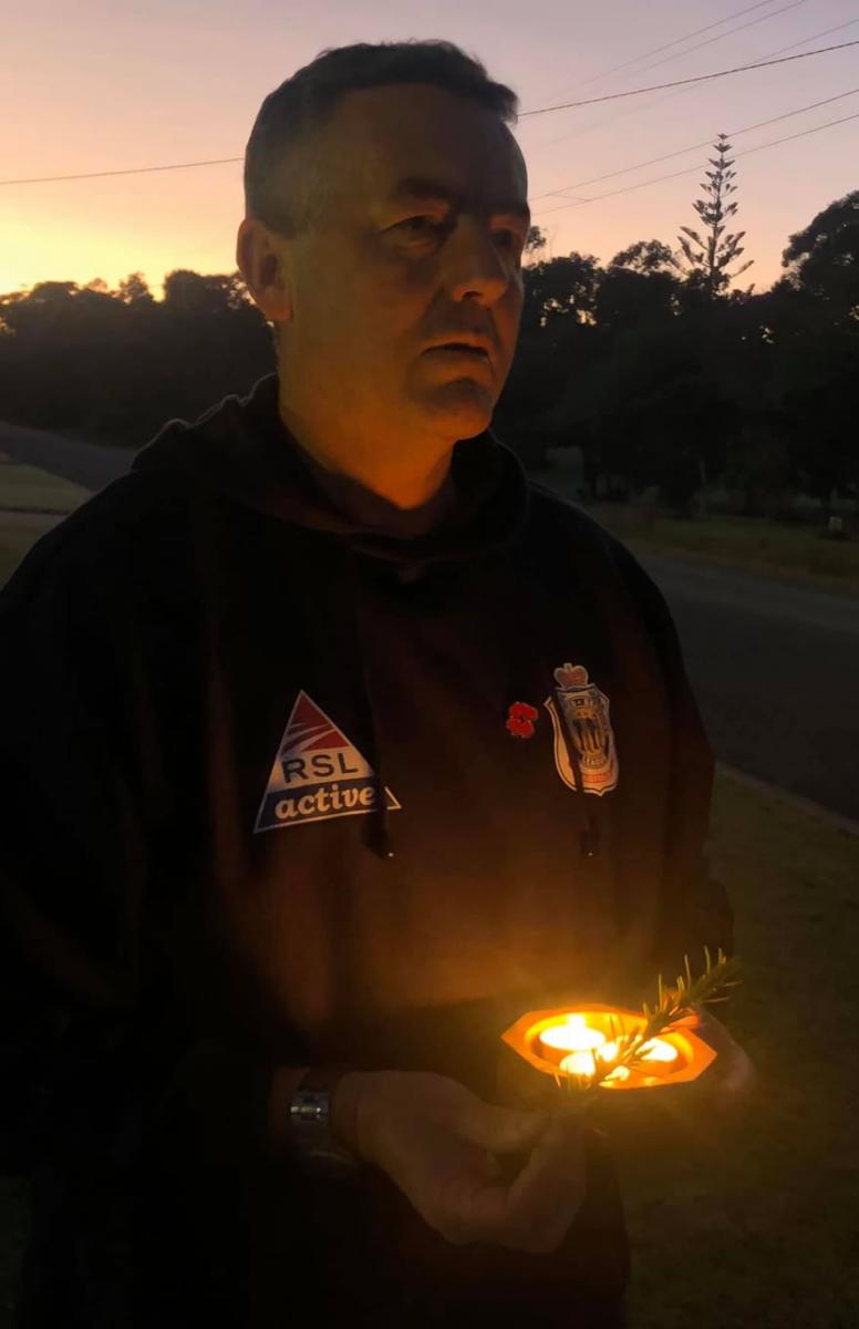 Darren Chester, holding a candle and standing on his driveway, during Anzac Day at home on 25 April 2020.