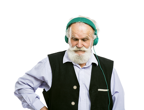 A man with grey hair wearing large headphones.