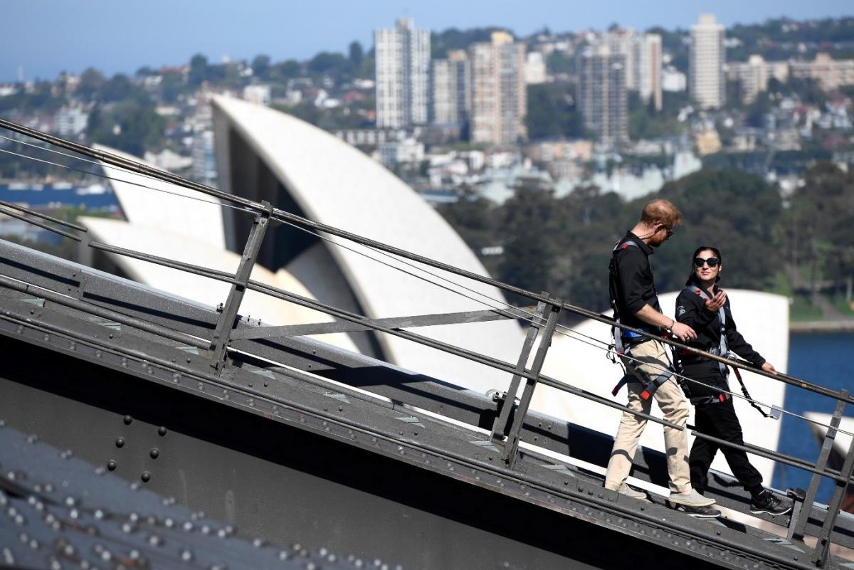 man and woman walking down Sydney Harbour Bridge