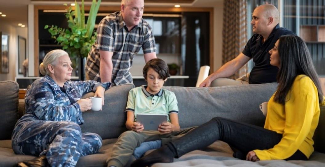 Family relaxing on sofa, including a woman in Air Force uniform