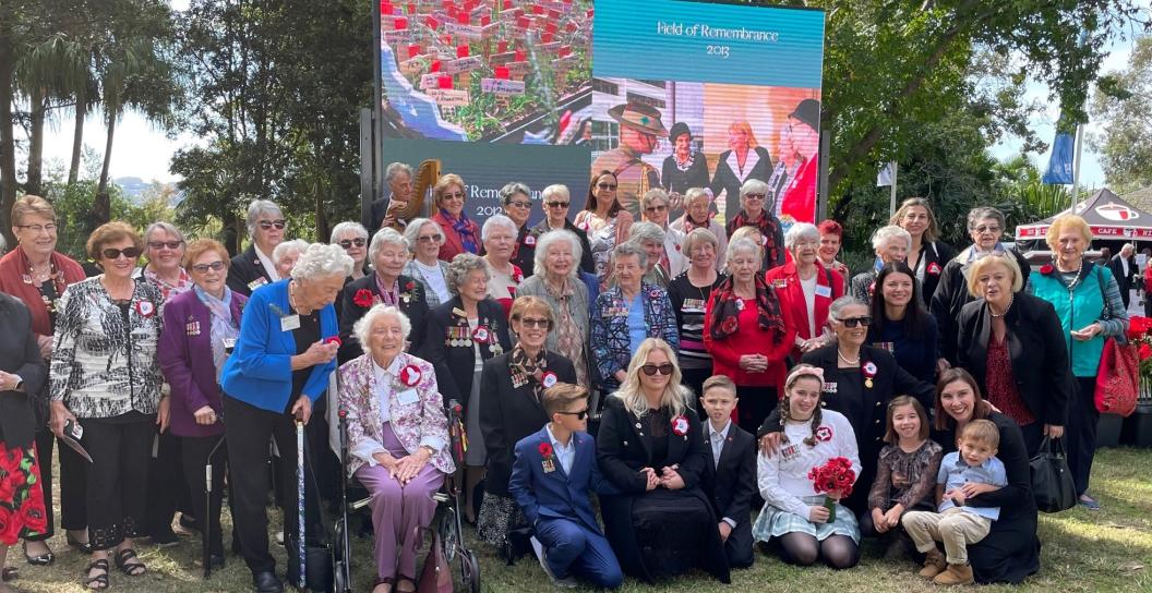 About 30 women in park posing in front of banner saying Field of Remembrance