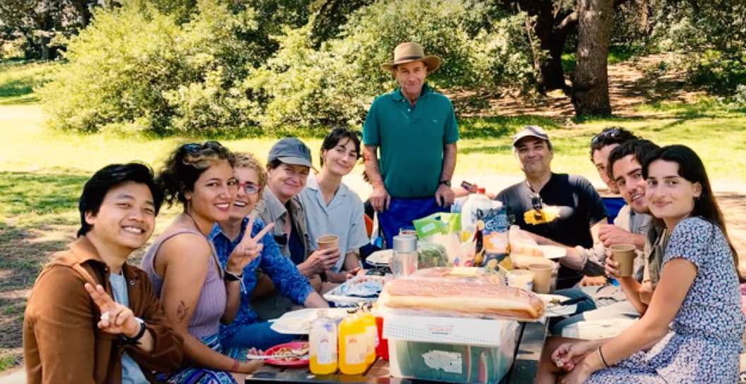 About 10 people gathered around picnic table