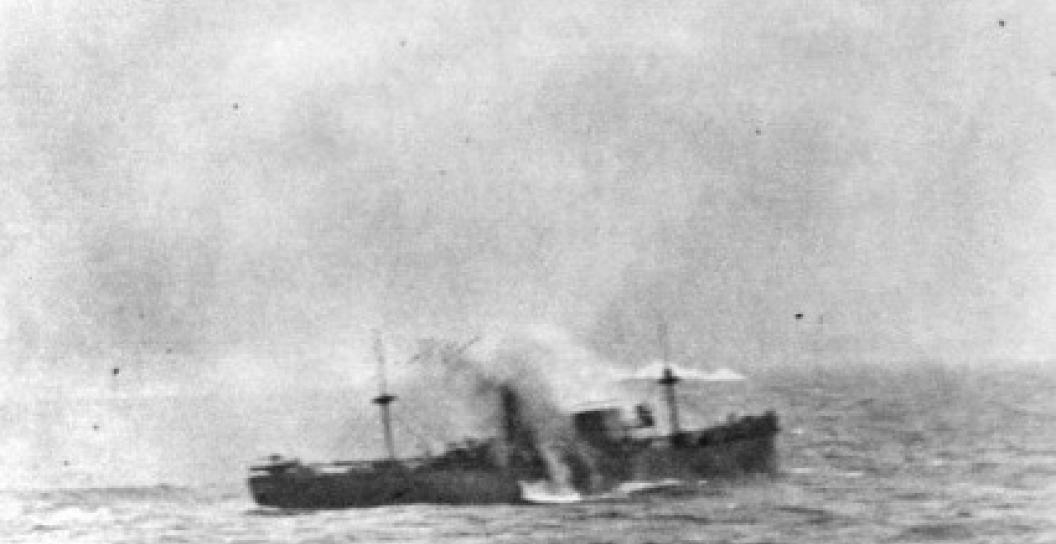 Shell explodes against hull of small ship