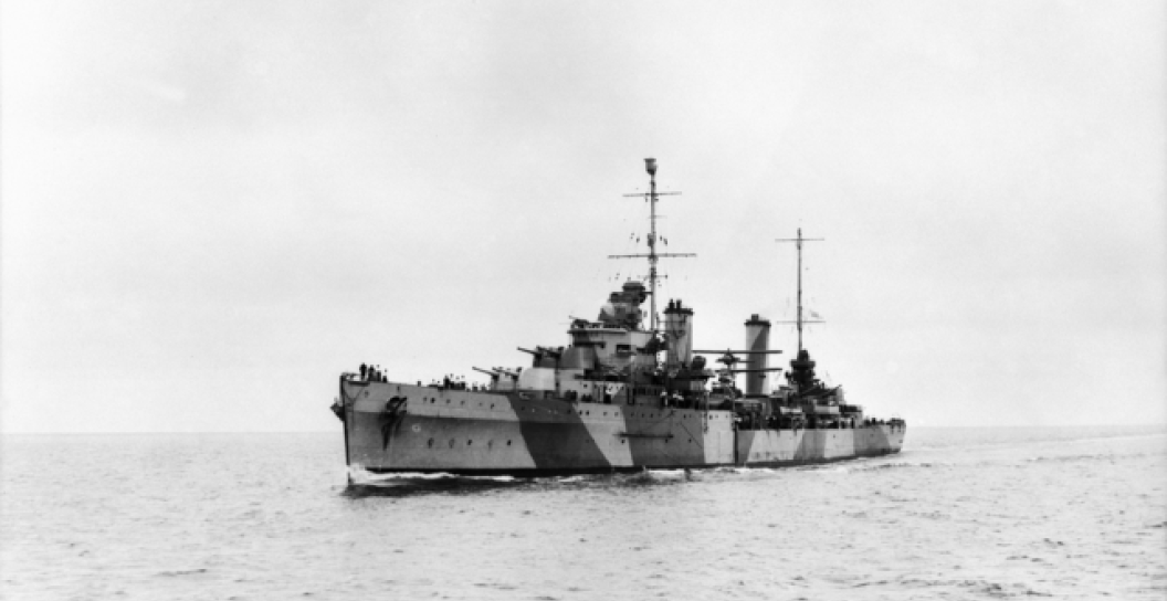 A cruiser with dazzle paint at sea in a black and white image.