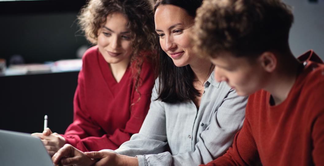 Group of young adults look at a computer screen