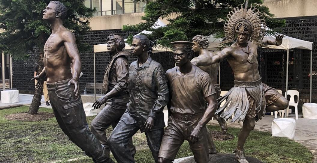 Bronze sculpture with five Indigenous men in various uniforms and traditional clothing