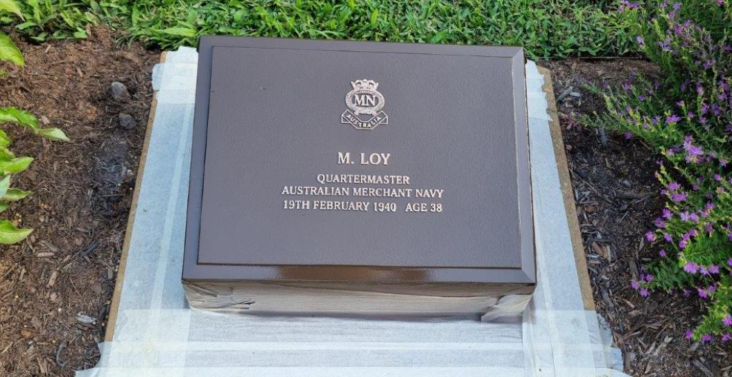 Restored bronze plaque surrounded by masking tape