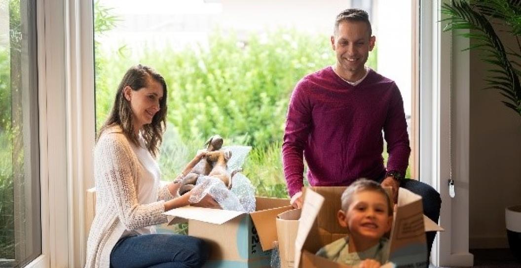 Man, woman and boy unpacking boxes in home