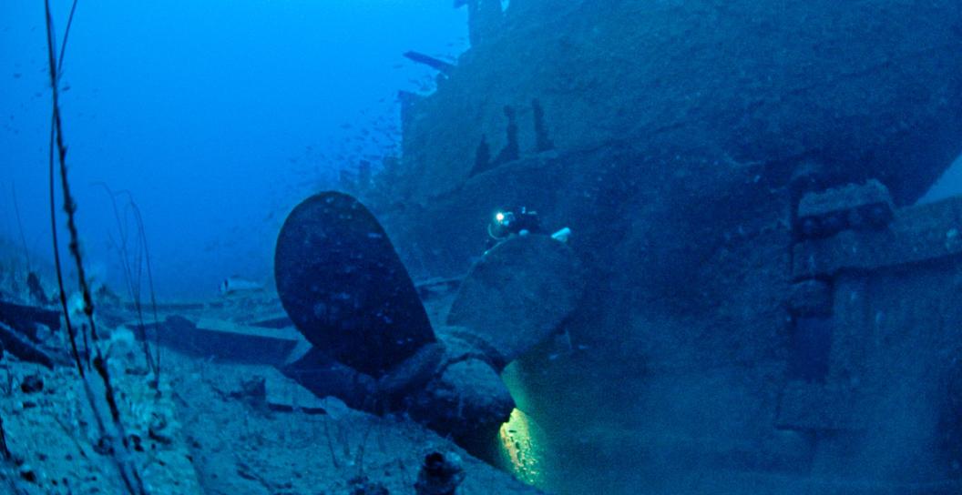 Remains of stern of ship on sea bed, with propeller in foreground