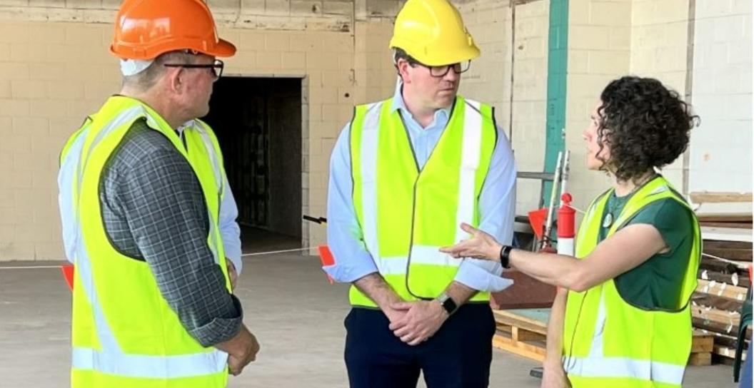 Minister Keogh wearing hard hat on construction site with colleagues