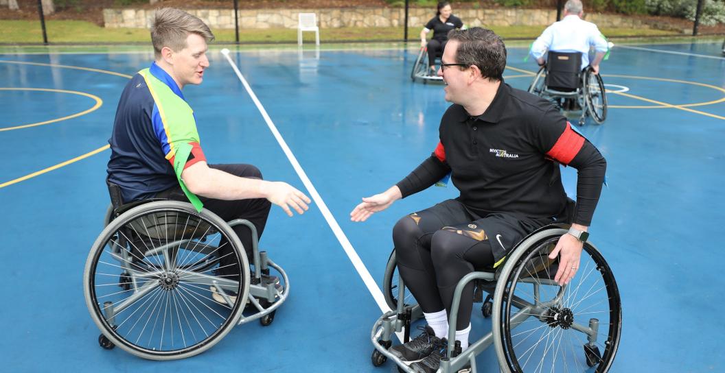 Minister for Veterans' Affairs Matt Keogh is trying out wheelchair rugby league, he is about to shake hands with a participant