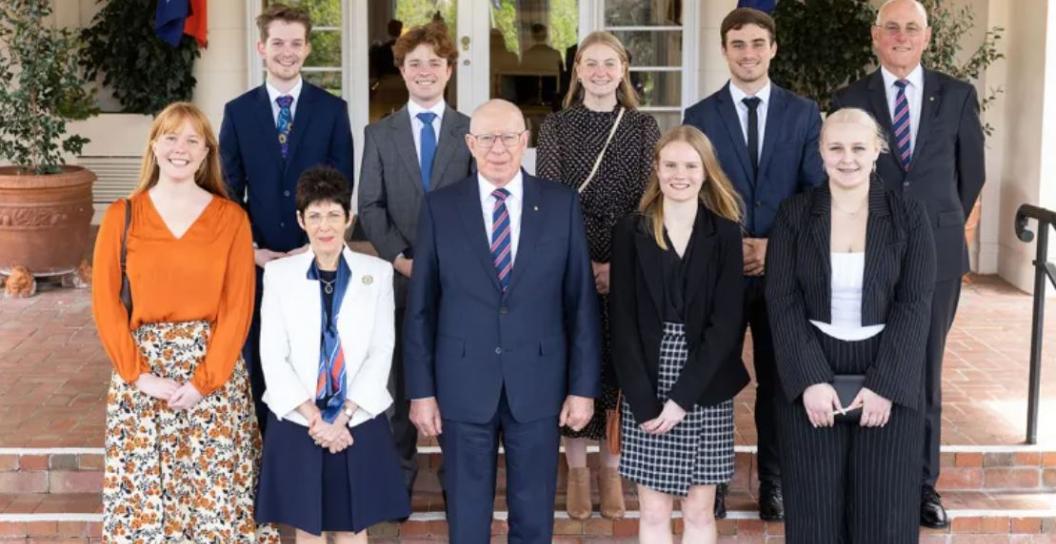 Three adults and seven teenagers pose for camera on steps of Government House, Canberra