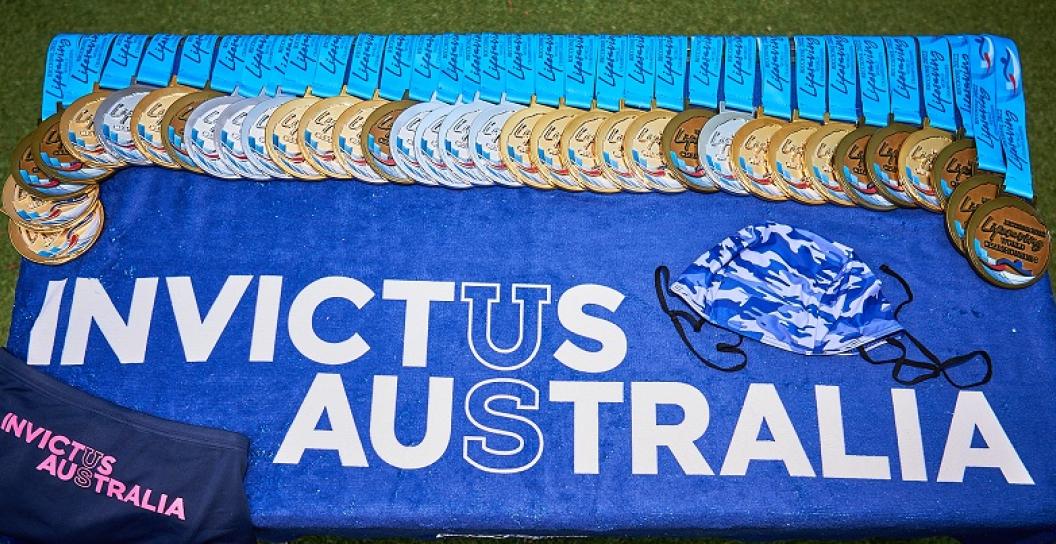 Thirty or so medals placed on banner saying 'Invictus Australia'