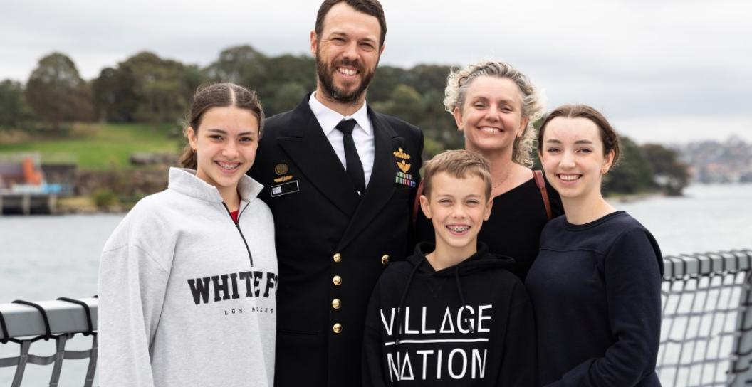 An ADF officer stands with his family