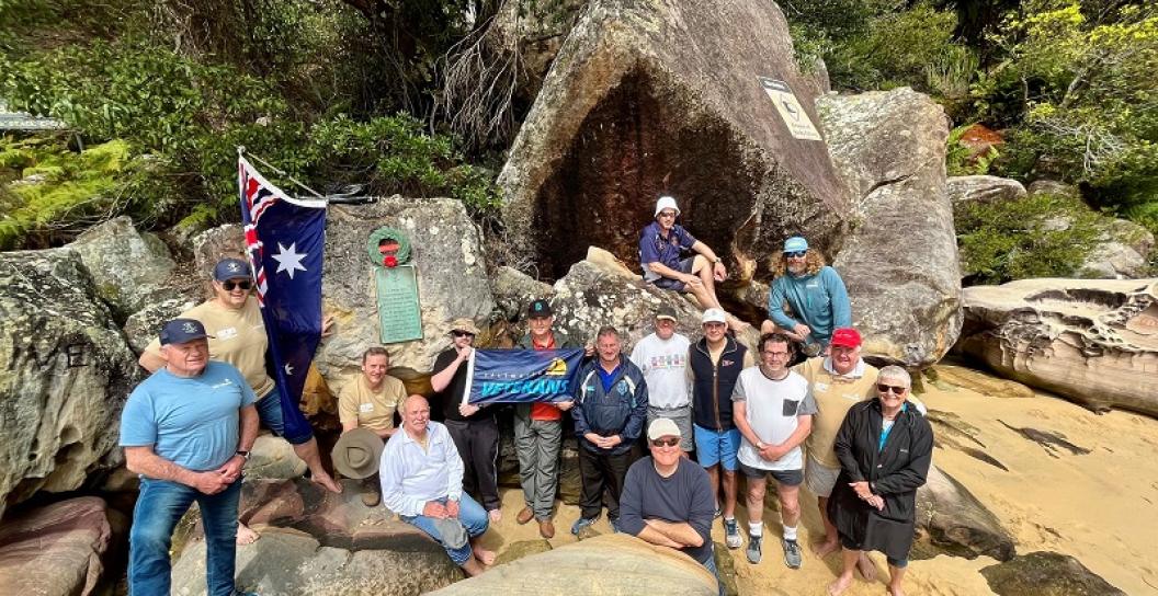 About ten people gathered on rocky beach
