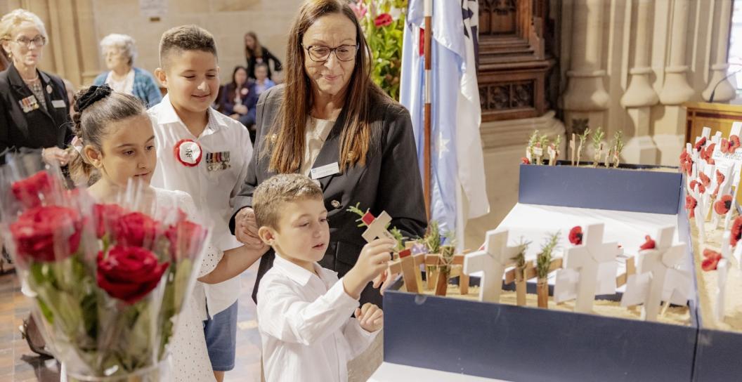 A woman and three children, one holding flowers, in a cathedral