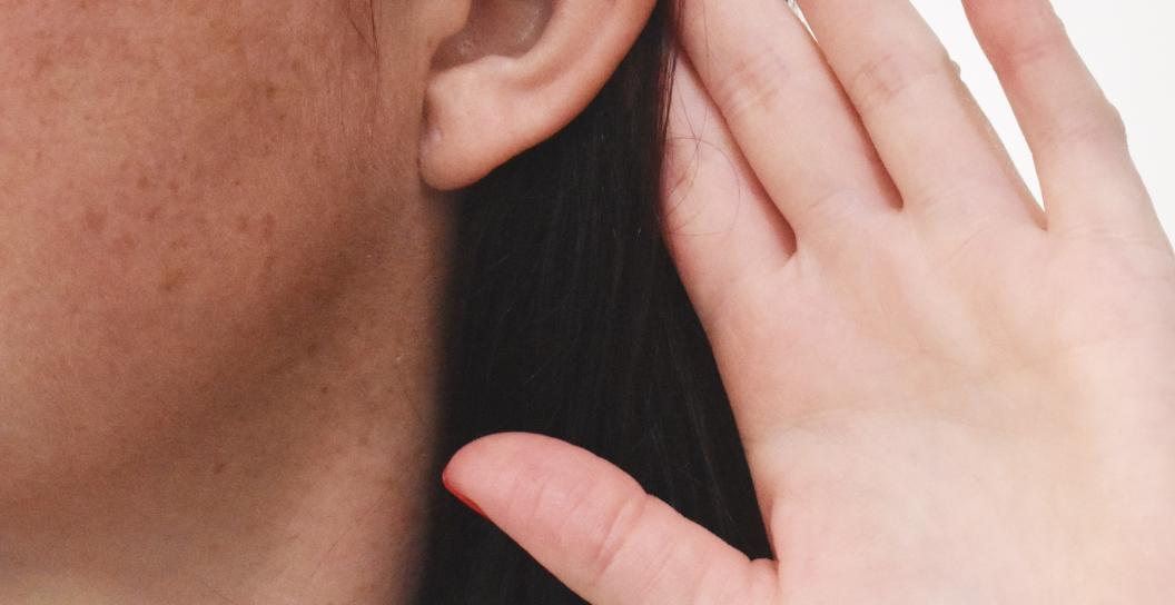 Person, struggling to hear - hand behind ear.