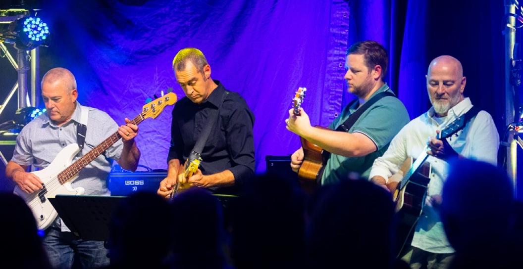 Four men playing the guitar