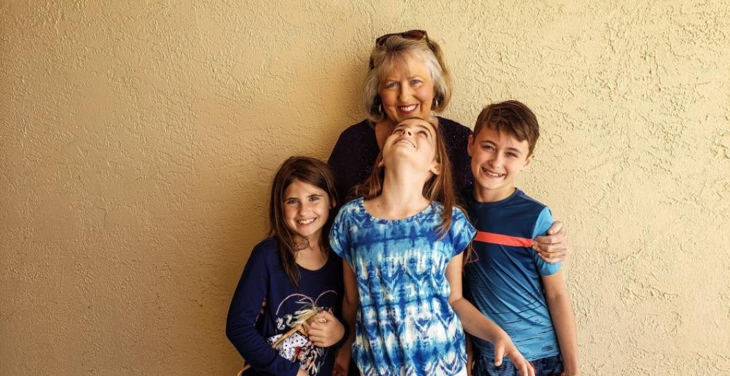 A grandmother stands with her three grandchildren
