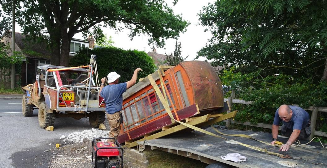 Ancient phone box being loaded onto flatbed truck