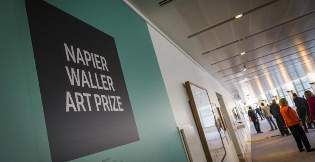 Gallery space with people milling and sign saying Napier Waller Art Prize