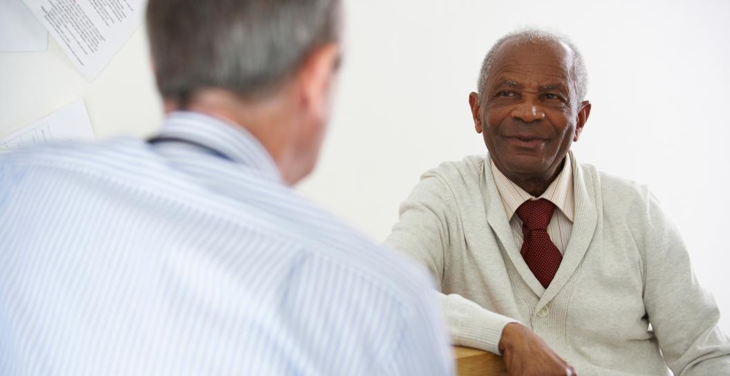Older man discusses diagnosis with doctor