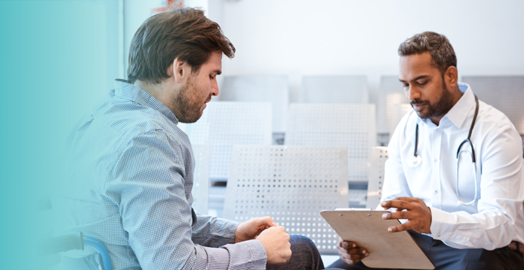 Man talking to doctor holding clipboard 