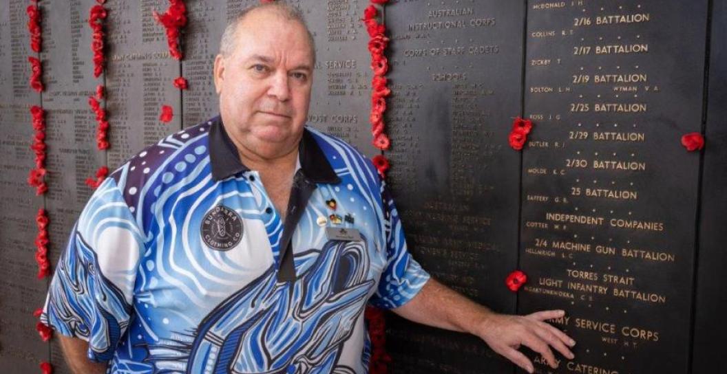 Australian War Memorial Indigenous Liaison Officer Michael Bell places a poppy beside the name of Private Ngakyunkwokka on the Roll of Honour.