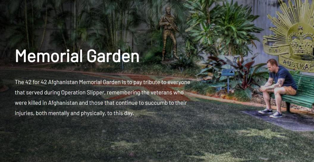 Photo of a man sitting on bench in a memorial garden