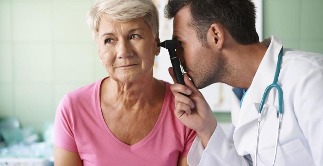 Doctor peering into ear of patient